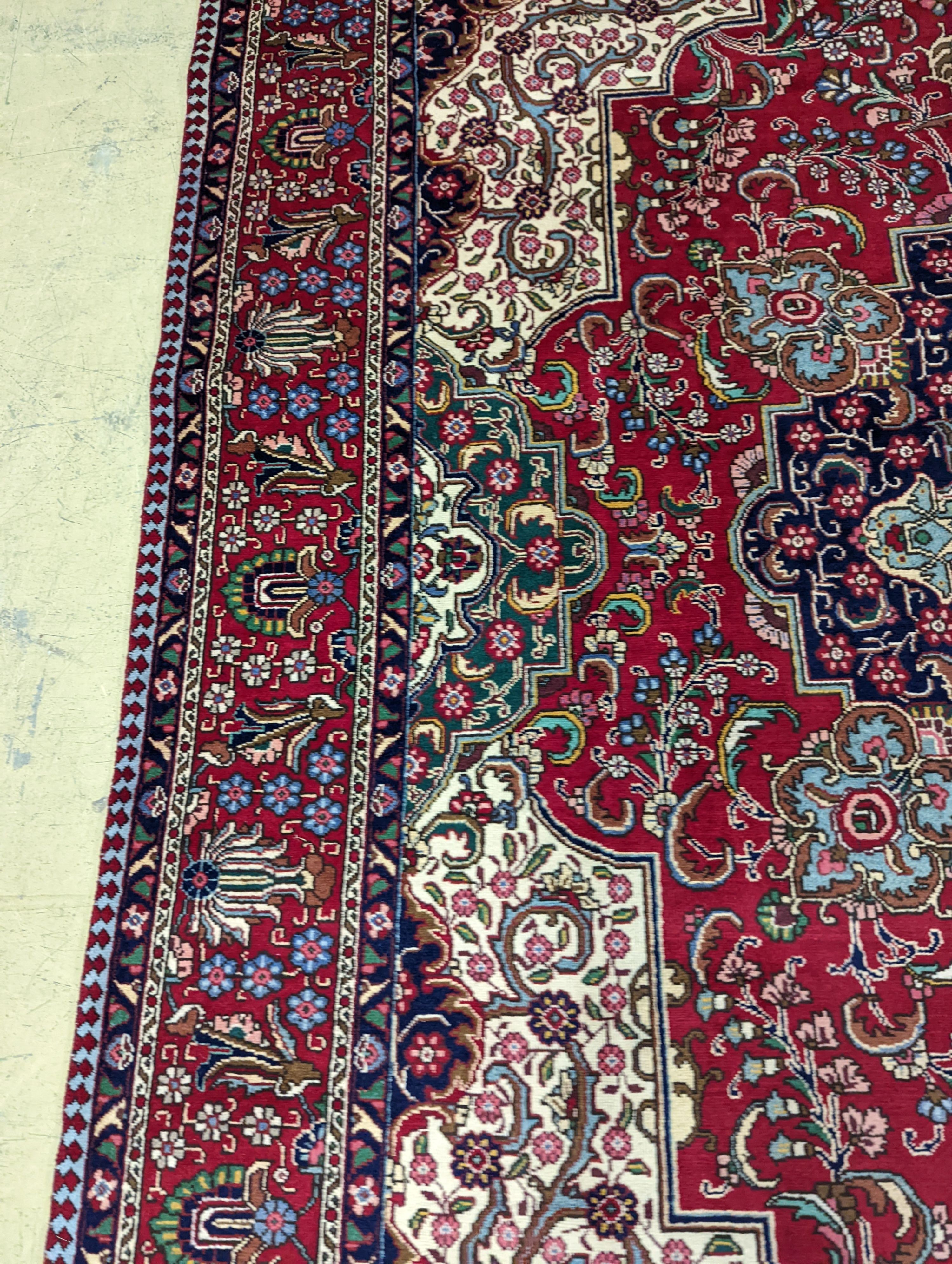 A Tabriz red ground carpet, 405 x 292cm
